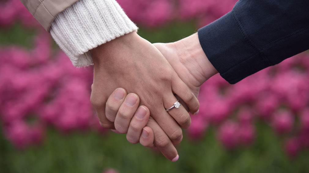 Engaged couple holding hands